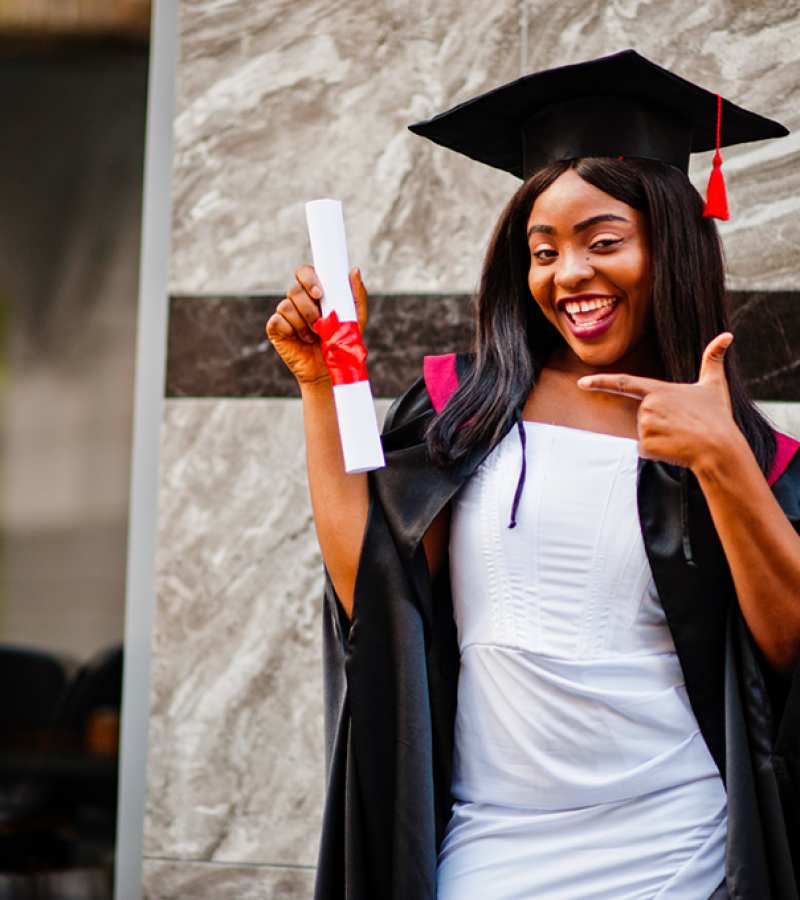 young-female-african-american-student-with-diploma-poses-outdoorsxa